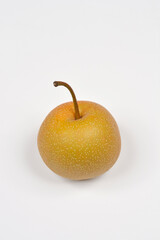 A single, whole unpeeled Asian pear with a stem stands on a white background, photographed from the...