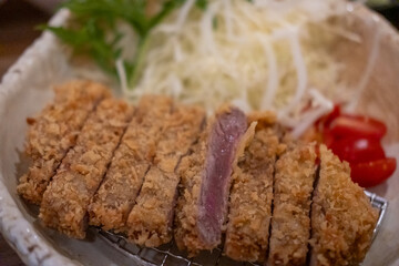 Set of Gyukatsu or beef cutlet served with cabbage. A traditional Japanese food that consists of a...