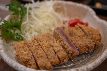 Set of Gyukatsu or beef cutlet served with cabbage. A traditional Japanese food that consists of a deep-fried beef cutlet.