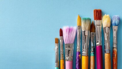 Colorful paintbrushes arranged on a light-blue background