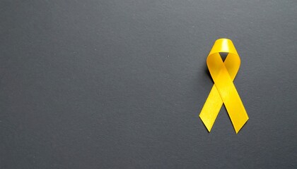 Golden Yellow Ribbon on Dark Background: Symbolizing Suicide Prevention, Childhood Cancer Awareness and World Cancer Day