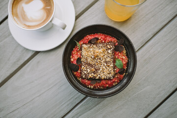 Gourmet Chocolate Dessert with Frothy Cappuccino and Fresh Juice on Rustic Table