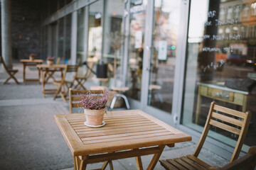 Cozy Outdoor Cafe Seating with Wooden Tables and Chairs on a Quiet City Street