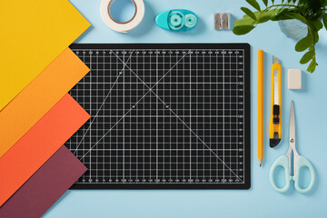Black cutting mat and other tools for paper crafts. Top view of the desktop, space for your text.