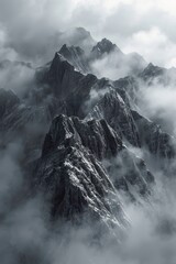 Majestic Snow-Capped Mountain Peaks Surrounded by Misty Clouds

