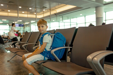Happy child, traveling with his family, waiting at the airport to board the aircraft