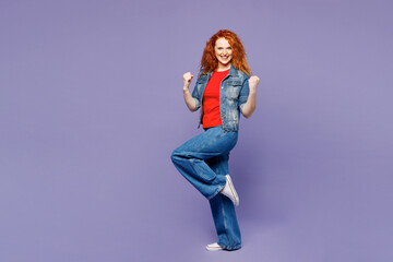 Full body young ginger woman wears red t-shirt denim shirt doing winner gesture celebrate clenching...