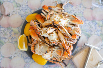 Freshly steamed blue crabs served with lemon wedges on a table
