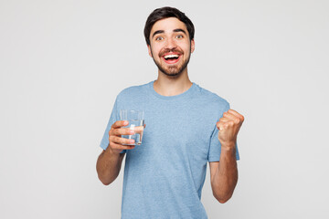 Young man wear blue t-shirt casual clothes drink clear pure still water from glass do winner...