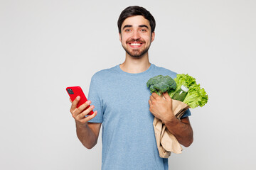 Young man he wear blue t-shirt casual clothes hold in hand packet with greenery use mobile cell...