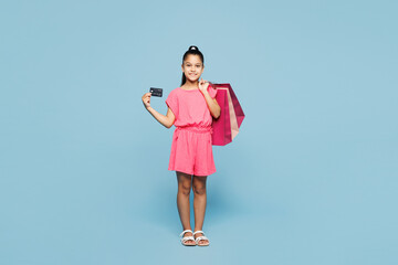 Full body happy little kid girl 9-10 years old wear pink clothes hold paper package bags after...
