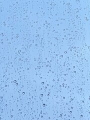 Minimalist water droplet texture on glass with soft blue tones, perfect for clean nature-inspired design and eco-aesthetic visuals