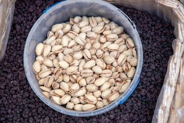 Hazelnuts, pistachios, almonds, cashews, pine nuts and dried fruits in baskets at a farmers market. Sale of nuts. Nuts and dried fruits are used in the preparation of sweet dishes - chocolate, candies