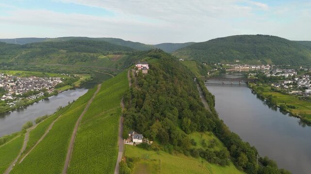 Marienburg castle on Petersberg, aerial panorama view over Moselle valley, vineyards, mountain range of Eifel and Hunsrueck, Mosel river loop near Zell, Germany