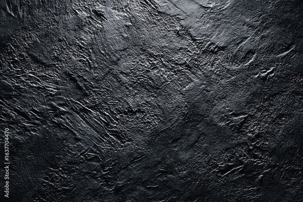 Poster textured black surface with intricate patterns illuminated by soft light creating a dramatic appeara