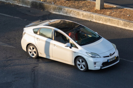 White toyota prius parked on asphalt road with sunroof