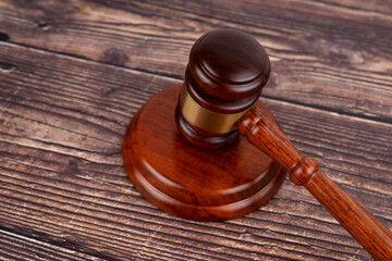 Wooden judge’s gavel and sound block on rustic wooden table, symbolizing justice, law, and...