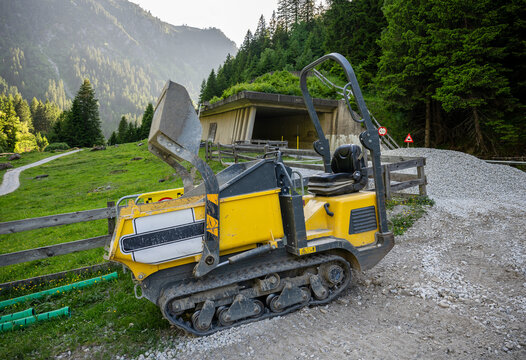 Compact tracked dumper at construction site in alpine mountain landscape