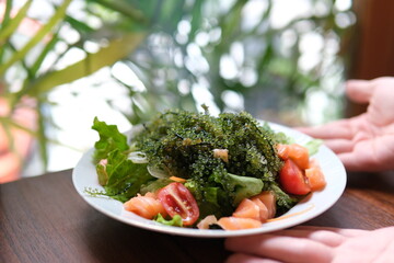 Caulerpa fresh green sea grape on wooden. plate of asian salad delicious in a restaurant beautiful...