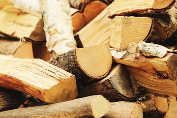 Stack of chopped firewood logs. Wooden pieces prepared for burning in fireplace or stove. Freshly...