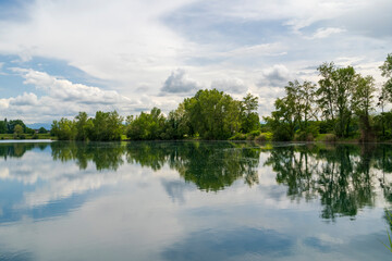 Lac de Bazet, France – Reflective Waters and Forested Shores.