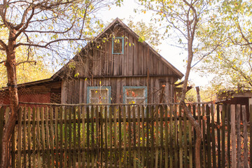 Naklejka premium A small wooden country house on a summer street. The house is old and abandoned.