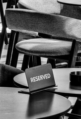 Reserved Sign on Indoor Bar Table. Monochrome Hues.