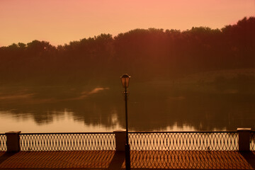Evening gloomy landscape of the city embankment with a lantern.