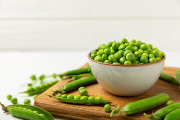 Fresh green pea pods with green peas on a wooden background. Sweet green peas. Green pea beans vegetables. Vegan. healthy vegetable. Copy space