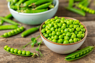Fresh green pea pods with green peas on a wooden background. Sweet green peas. Green pea beans vegetables. Vegan. healthy vegetable. Copy space