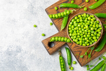 Fresh green pea pods with green peas on a wooden background. Sweet green peas. Green pea beans vegetables. Vegan. healthy vegetable. Copy space
