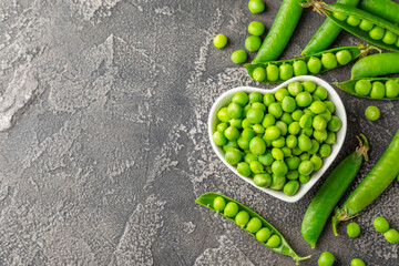 Fresh green pea pods with green peas on a wooden background. Sweet green peas. Green pea beans...