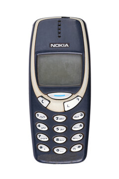 Old Nokia 3310 mobile phone showing retro design close-up isolated on white background.