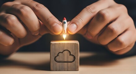 Concept of business startup and cloud computing. Hands launch a miniature rocket from a wooden block with a cloud icon, symbolizing new technology deployment and growth