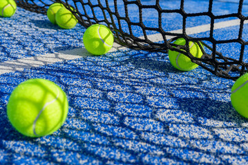 The shadow of the net falls over yellow tennis balls on the court leisure and sport concept