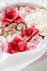 Vibrant floral arrangement featuring red and white flowers nestled in soft tissue paper, showcasing the beauty of nature and the art of floral design in a delicate presentation