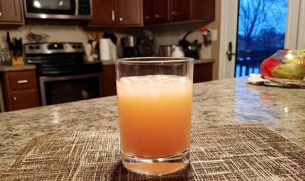Butterscotch schnapps cocktail featuring rich caramel color with ice and citrus garnish in a casual kitchen setting