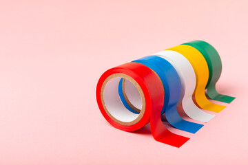 Insulating tape on a bright colored background. Set of different colors insulating tape. Reel...