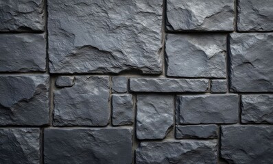 Close-up of a textured dark stone wall emphasizing unique shapes and patterns.
