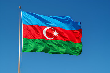 The flag of Azerbaijan waves against a clear blue sky.
