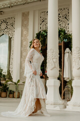  Beautiful slim blonde poses in boho wedding dresses and an embroidered corset on a summer terrace.