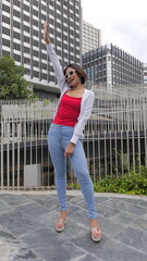 A stylish young Asian woman with a bob haircut stands confidently in a white hoodie and a red tank...
