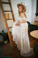  Beautiful slim blonde poses in boho wedding dresses and an embroidered corset on a summer terrace.