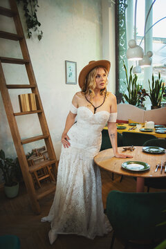  Beautiful slim blonde poses in boho wedding dresses and an embroidered corset on a summer terrace.