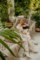  Beautiful slim blonde poses in boho wedding dresses and an embroidered corset on a summer terrace.