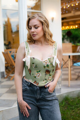  Beautiful slim blonde poses in boho wedding dresses and an embroidered corset on a summer terrace.