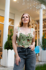  Beautiful slim blonde poses in boho wedding dresses and an embroidered corset on a summer terrace.