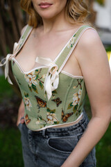  Beautiful slim blonde poses in boho wedding dresses and an embroidered corset on a summer terrace.