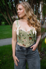  Beautiful slim blonde poses in boho wedding dresses and an embroidered corset on a summer terrace.