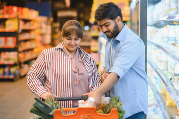 Indian couple choosing products in grocery store
